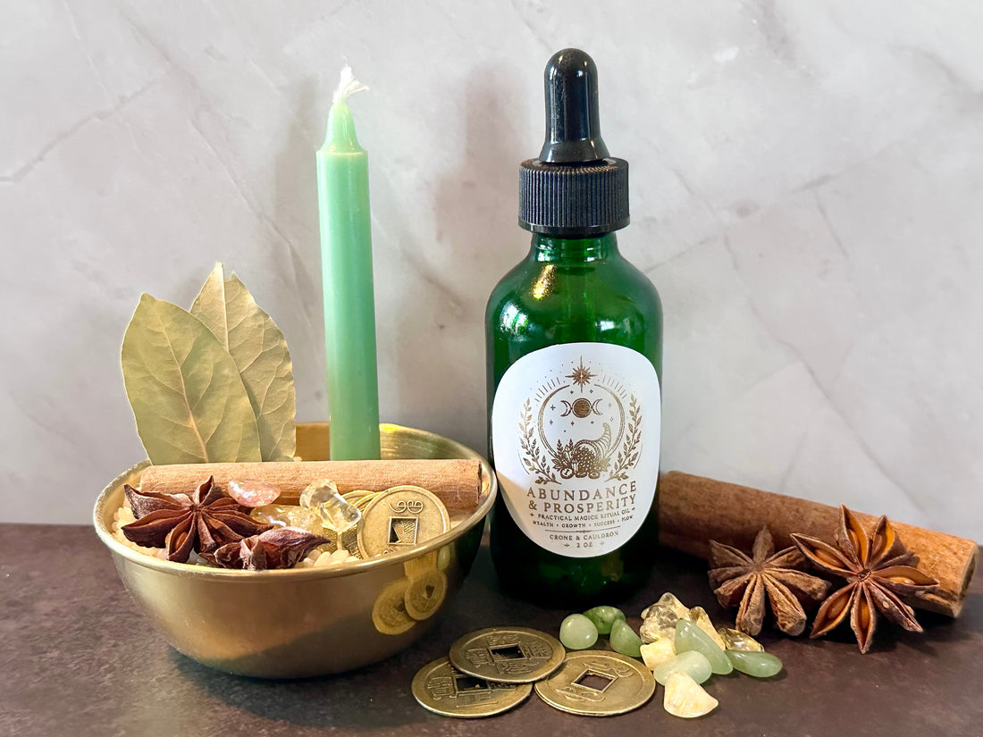 Money bowl with coins, cinnamon, bay leaves, crystals, green candle, and Abundance and Prosperity ritual oil for prosperity magic
