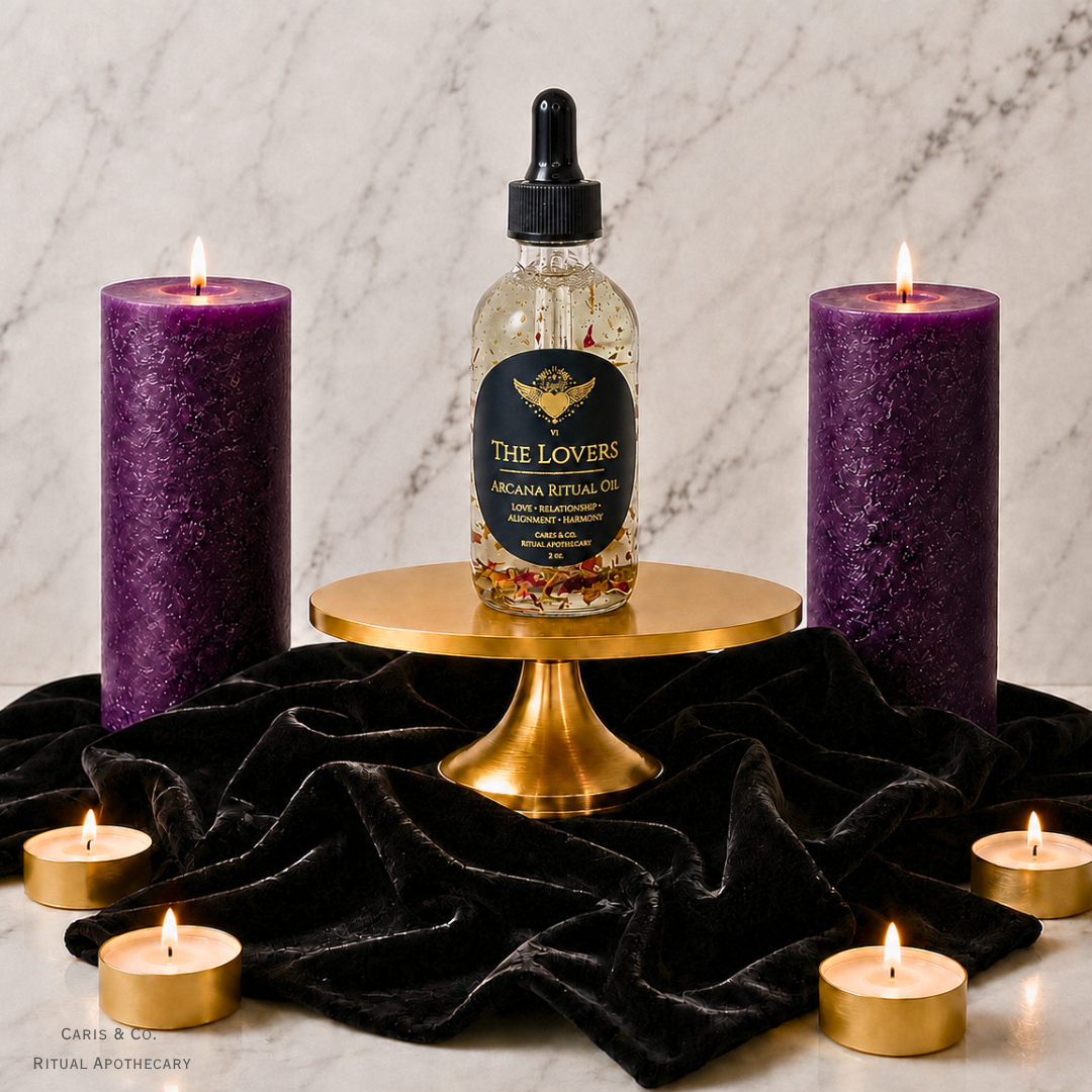A bottle of 'The Lovers' Arcana Ritual Oil by Caris & Co. Ritual Apothecary is displayed on a gold pedestal, flanked by two large purple pillar candles and four small tealight candles on a black velvet cloth against a marble background.
