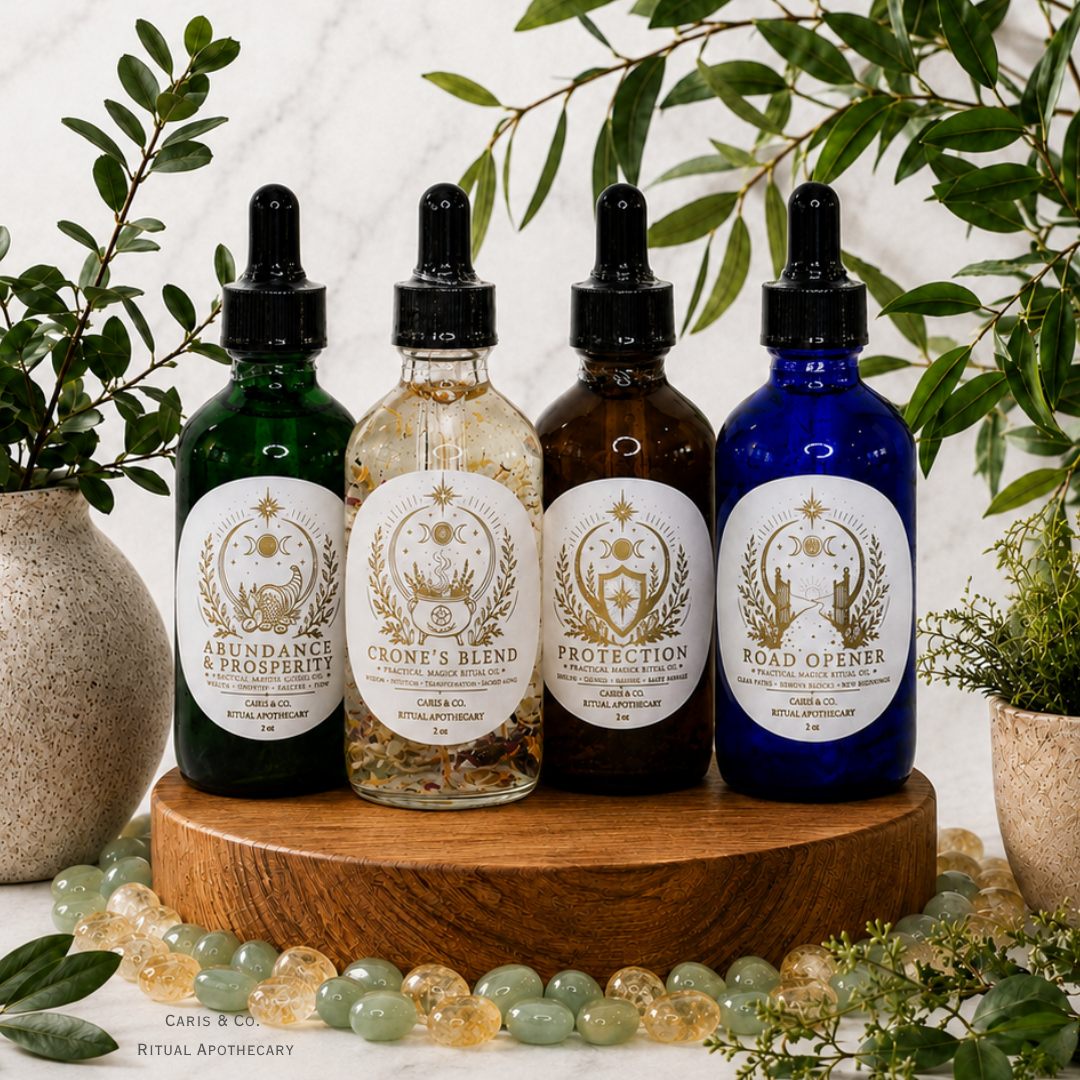 Four glass dropper bottles with black caps are arranged on a round wooden pedestal. The bottles are green, translucent beige, dark brown, and cobalt blue, each with a large white label featuring a circular emblem and the text  Caris & Co. Ritual Apothecary