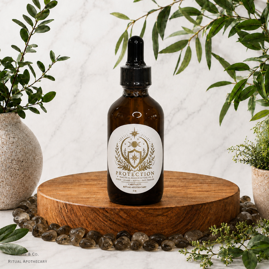 An amber glass dropper bottle labeled 'PROTECTION' by  Caris & Co. Ritual Apothecary, displayed on a round wooden pedestal with green foliage and small stones around it against a light marble background.