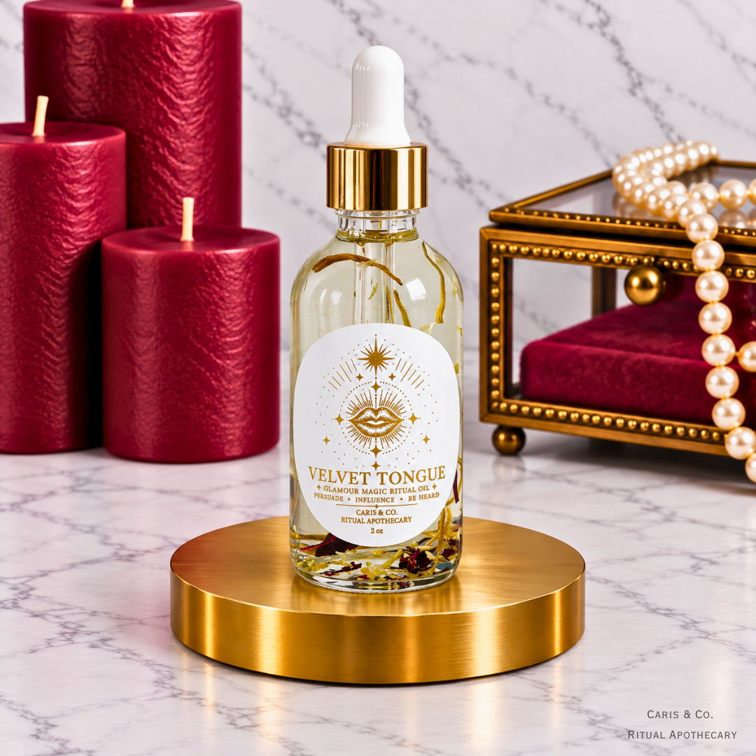 Caris & Co. Velvet Tongue glamour magic ritual oil bottle with red candles and pearl jewelry on a marble background.